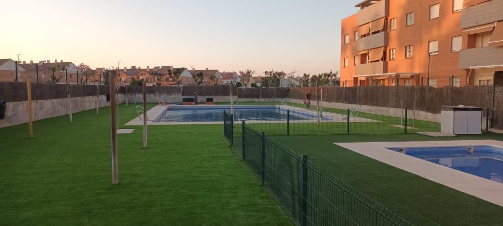 Césped artificial instalado en zona comunitaria de piscina - Limcesped Sevilla
